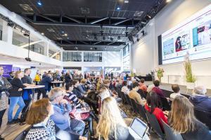 Eine Messehalle der Bildungsmesse Thüringen in 2022. Jeder Stuhl ist besetzt für die Vorträge über Digitalisierung und digitale Bildung